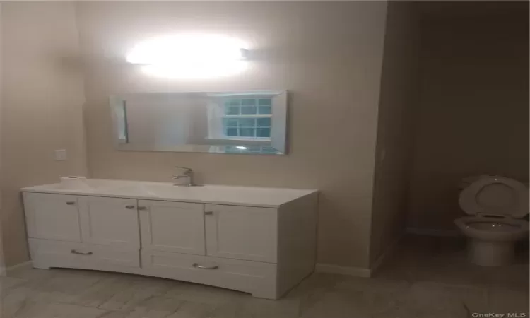 Bathroom featuring tile flooring, toilet, and vanity