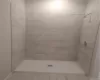 Bathroom featuring tiled shower and tile flooring