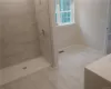 Bathroom featuring tiled shower and tile flooring