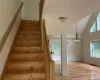 Stairs with high vaulted ceiling and light hardwood / wood-style floors