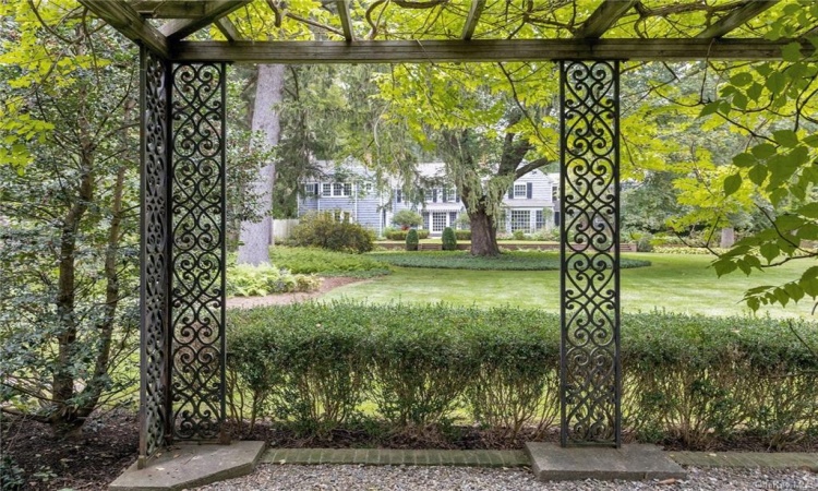 View of the home from the brick and iron portico