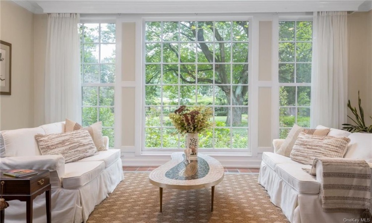 Two steps down from the dining room is this comfortable sunroom- perfect for breakfast, reading, etc.