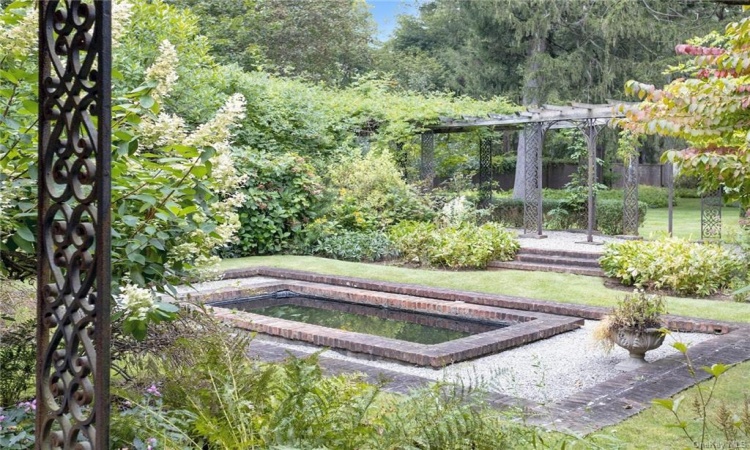 Reflecting pond has a fountain and flowers which bloom throughout the season