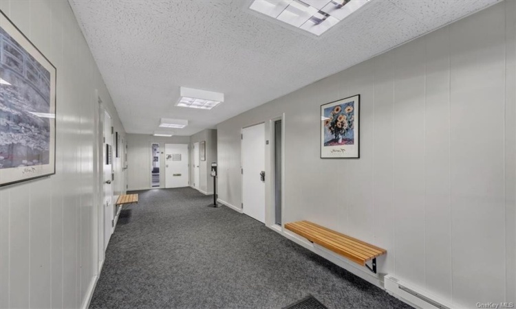 Clean and neat common hallway with sitting benches.