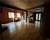 Unfurnished living room with wooden walls, wooden ceiling, dark hardwood / wood-style flooring, and track lighting