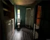 Bathroom featuring hardwood / wood-style flooring, washing machine and dryer, wooden ceiling, wooden walls, and toilet