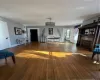 Living room with dark hardwood / wood-style floors, a notable chandelier, and radiator heating unit