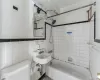 Bathroom with tile walls, toilet, and tiled shower / bath combo