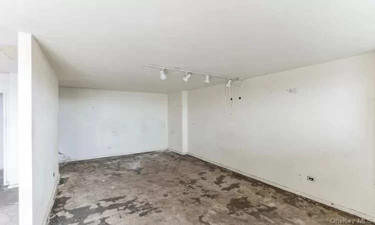 Empty room with rail lighting and concrete flooring