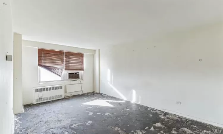 Unfurnished room with radiator and cooling unit