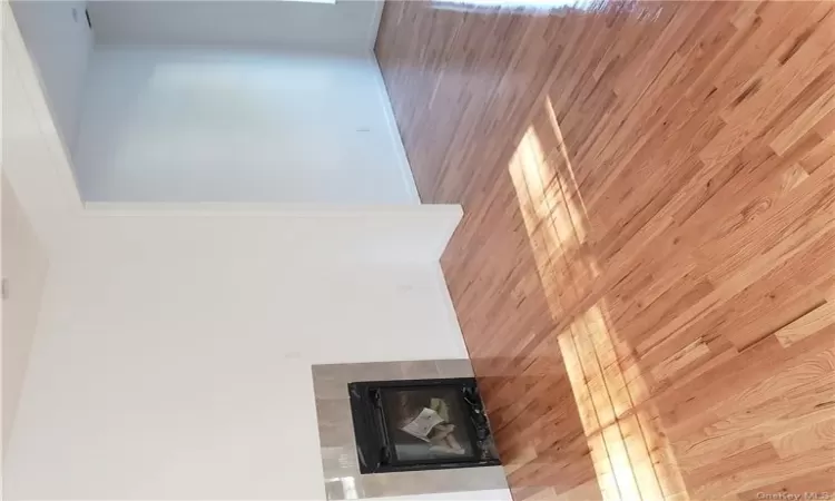 Unfurnished living room with light hardwood / wood-style flooring and a tiled fireplace