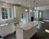 Kitchen featuring a kitchen island, dark hardwood / wood-style floors, pendant lighting, sink, and white cabinetry