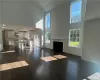 Unfurnished living room with a wealth of natural light, dark wood-type flooring, and a high ceiling