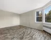 Unfurnished room featuring radiator heating unit and light hardwood / wood-style flooring