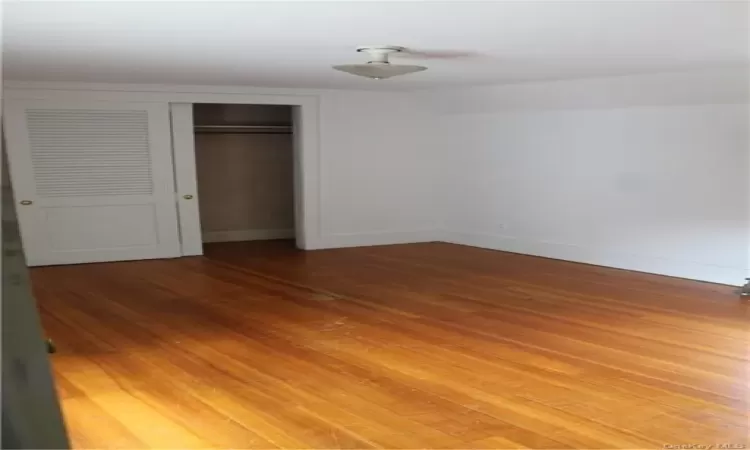 Unfurnished bedroom featuring a closet, vaulted ceiling, and light hardwood / wood-style flooring