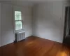 Spare room with radiator, vaulted ceiling, and dark hardwood / wood-style floors