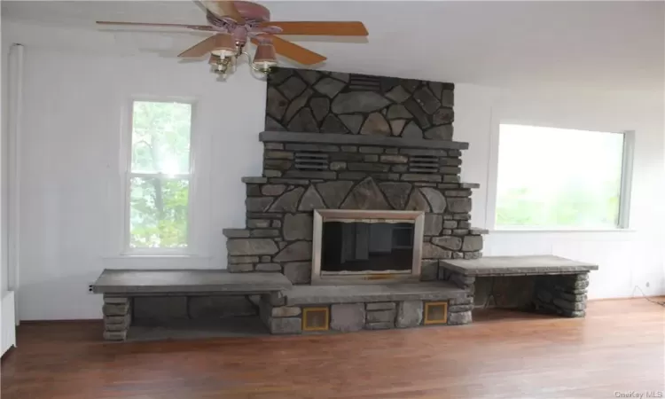 Unfurnished living room with hardwood / wood-style floors, ceiling fan, and plenty of natural light