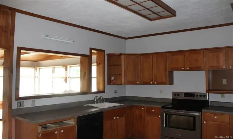 Kitchen featuring dishwasher, crown molding, sink, stainless steel range with electric cooktop, and a textured ceiling