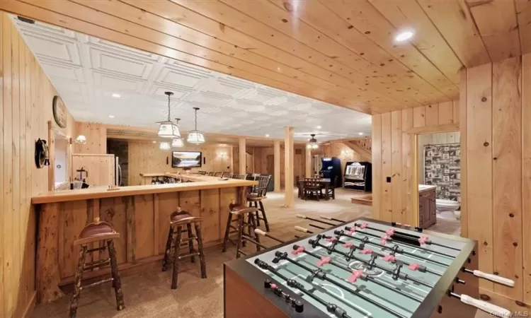 Game room featuring wood walls and light carpet