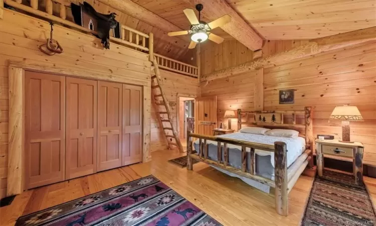 Bedroom with beamed ceiling, light wood-type flooring, and wooden ceiling