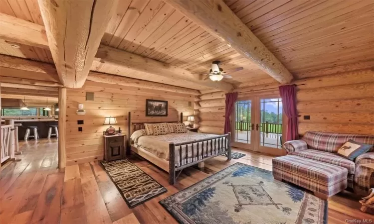 Bedroom with beamed ceiling, hardwood / wood-style floors, and wood ceiling