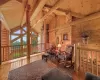 Living area with beam ceiling, wooden walls, wood ceiling, hardwood / wood-style flooring, and high vaulted ceiling