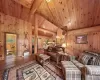 Living room featuring wood-type flooring, wooden ceiling, lofted ceiling with beams, and wooden walls