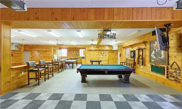 Rec room with tile flooring, wooden walls, and billiards