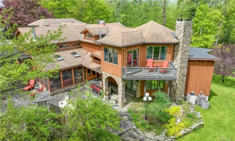 Rear view of property with a yard, a sunroom, and a patio area