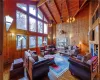 Living room with wooden walls, high vaulted ceilings,fireplace, and hardwood / wood-flooring