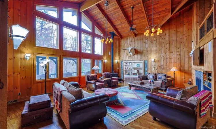 Living room with wooden walls, high vaulted ceilings,fireplace, and hardwood / wood-flooring