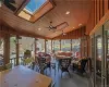 Sunroom / solarium featuring wooden ceiling, lofted ceiling with skylight, and ceiling fan