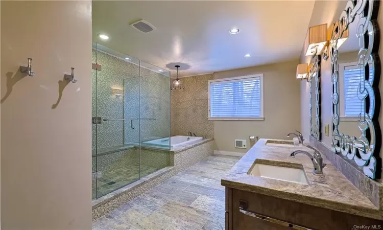 Bathroom featuring double vanity, independent shower and bath, and tile floors