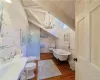 Full bathroom with hardwood / wood-floors, lofted ceiling with beams, sink, wood walls, and toilet