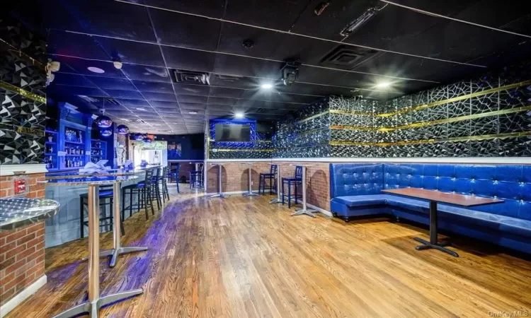 Recreation room with bar area and hardwood / wood-style flooring