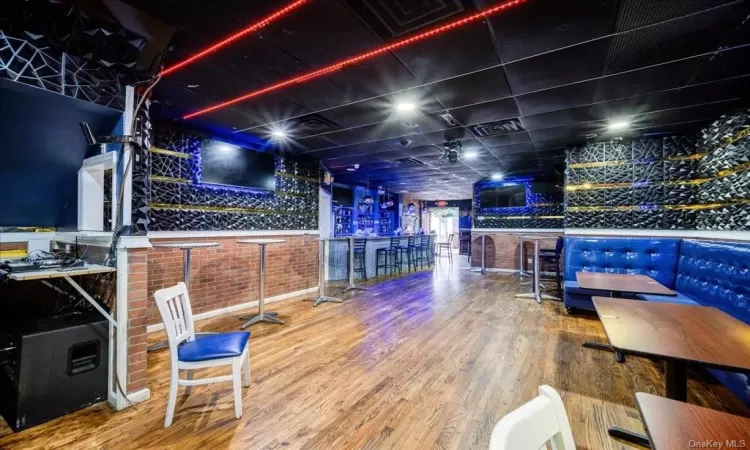 Recreation room with bar area and hardwood / wood-style flooring