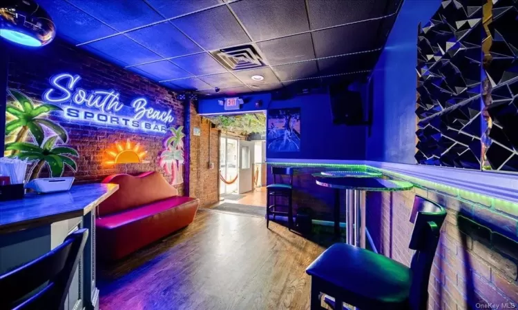 Recreation room with bar area and hardwood / wood-style flooring