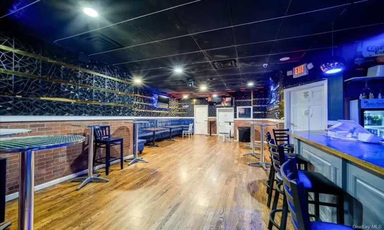 Recreation room with bar area and hardwood / wood-style flooring