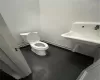 Bathroom featuring concrete floors, toilet, and a textured ceiling