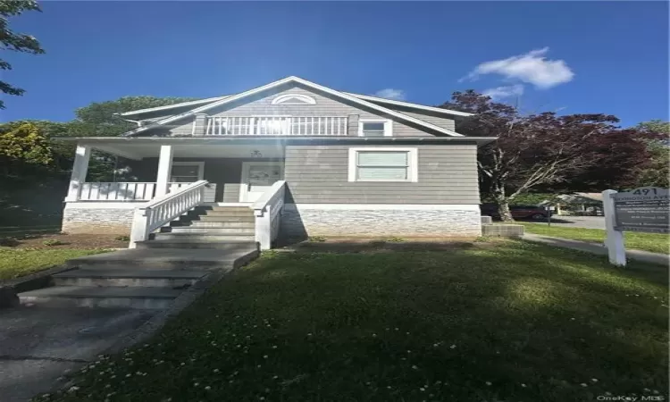 View of front facade with covered porch and a front lawn