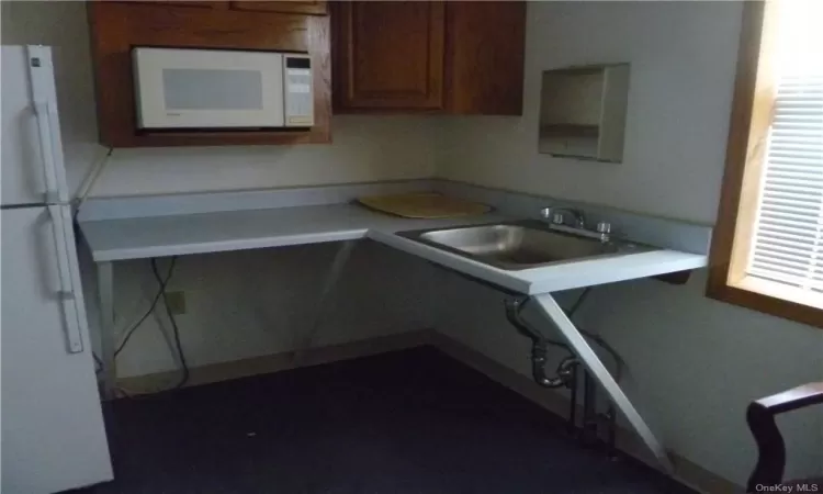 Kitchen featuring white appliances and sink