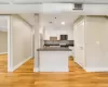 Kitchen with light hardwood / wood-style floors, a kitchen island, white cabinetry, appliances with stainless steel finishes, and sink