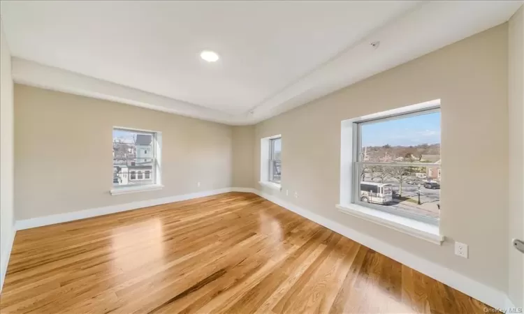 Unfurnished room featuring a healthy amount of sunlight and light hardwood / wood-style floors