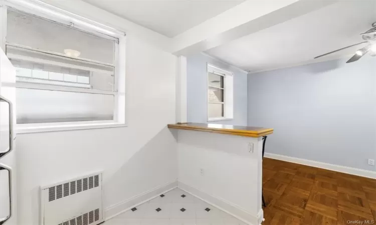 Kitchen featuring tile flooring, radiator, and ceiling fan