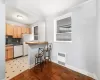 Kitchen with backsplash, radiator, tile flooring, sink, and white appliances