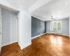 Empty room with crown molding, ceiling fan, radiator heating unit, and parquet flooring