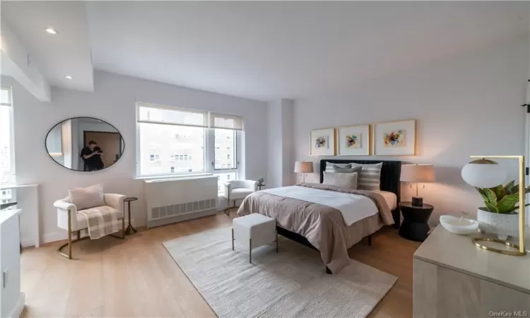 Bedroom featuring light hardwood / wood-style flooring and radiator heating unit