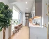 Kitchen featuring stainless steel appliances, backsplash, white cabinetry, light wood-type flooring, and sink