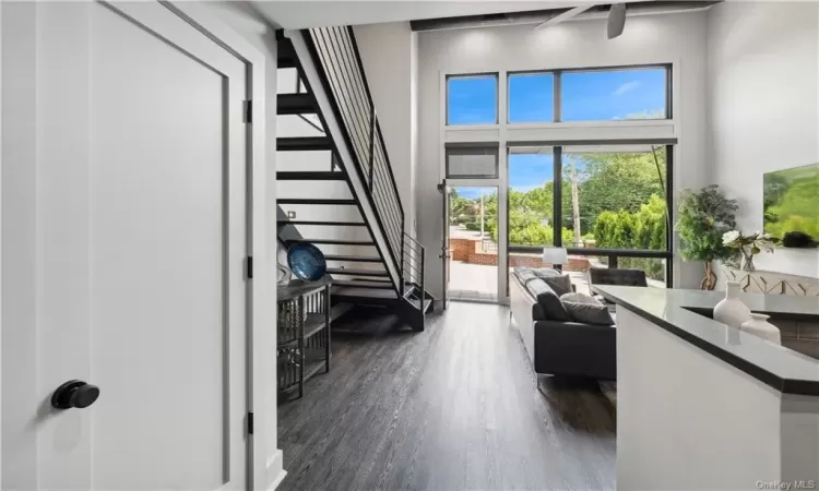 Living room featuring a towering ceiling and dark wood-type flooring