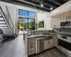 Kitchen with dark hardwood / wood-style floors, rail lighting, sink, and appliances with stainless steel finishes